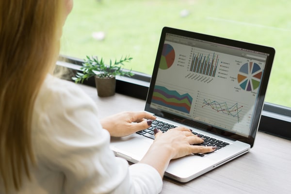 woman on laptop looking at data charts