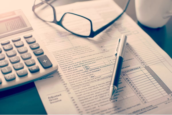 glasses, calculator, and pen on top of paperwork