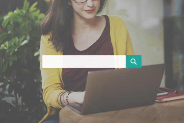 search box over woman using laptop on a table