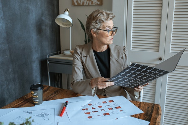 woman with designs on her desk looking through folder